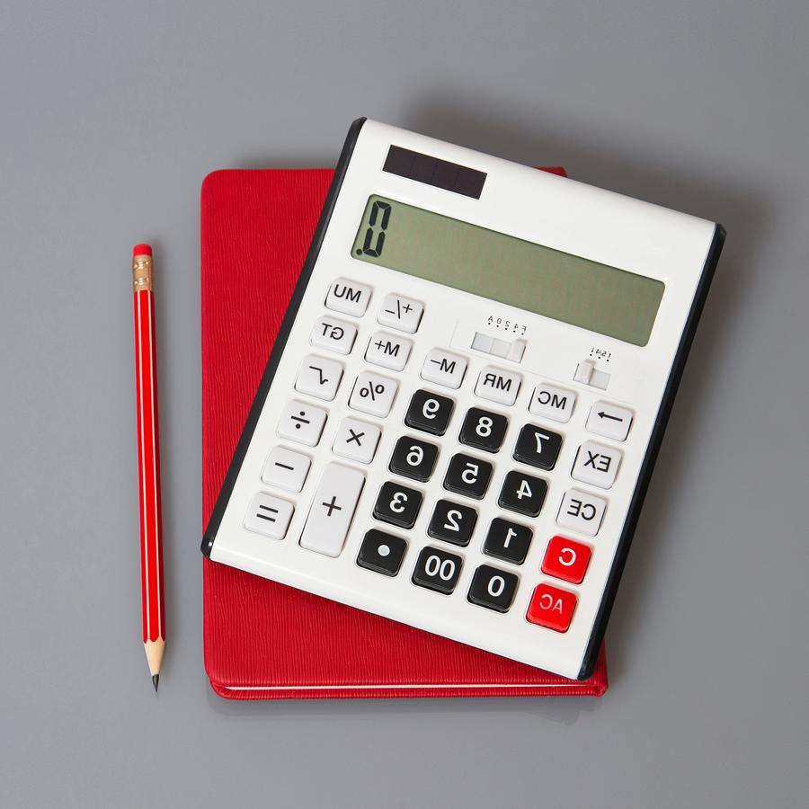 Calculator sitting on top of a notebook with a pencil